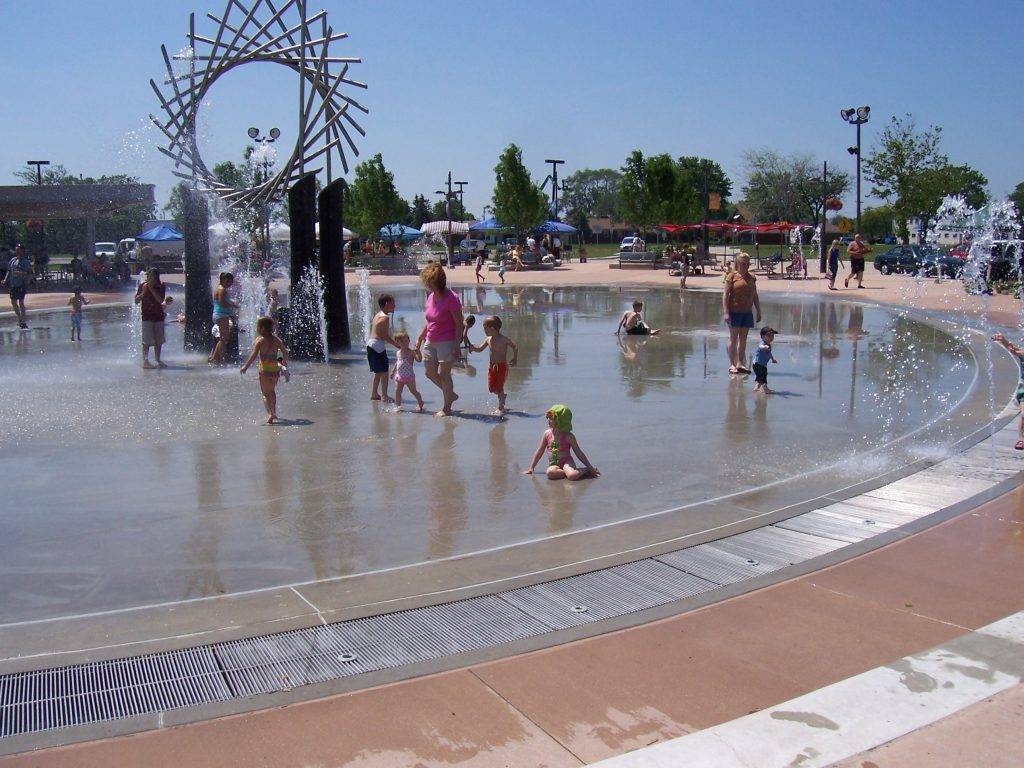 children and adults walk and play on a wet surface