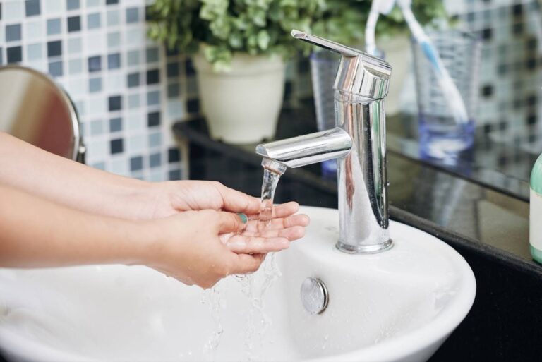 Woman washing her hands in the bathroom with soft water